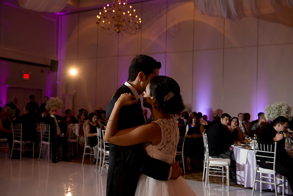 bride and groom dancing under spotlight