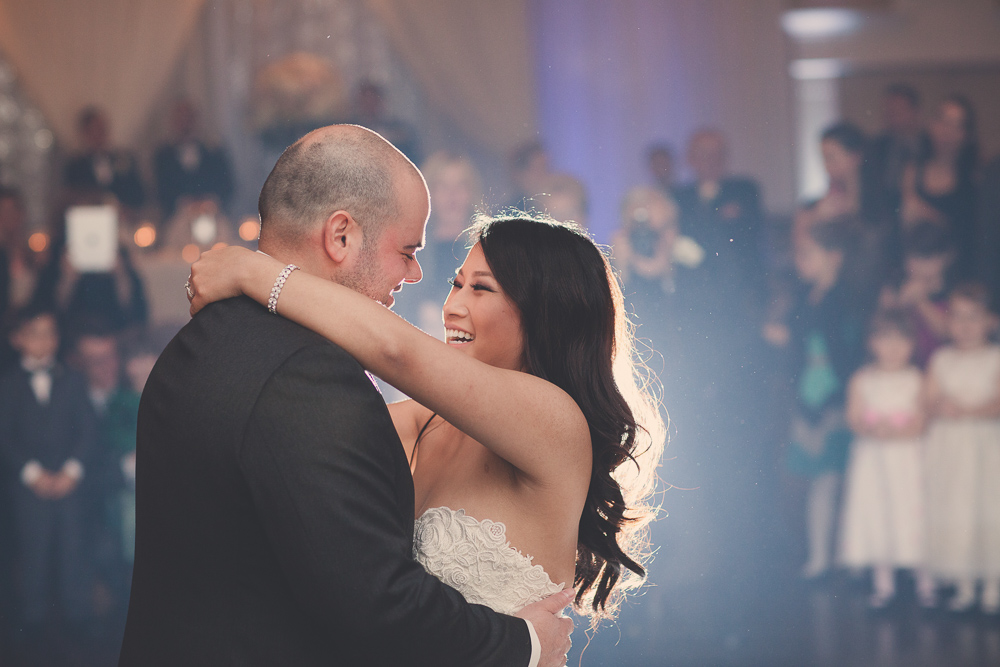 close up of bride and groom laughing during first dance