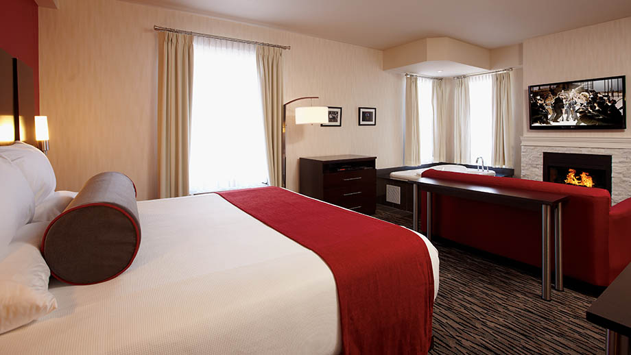 hotel room with king sized bed, fire place and whirlpool tub