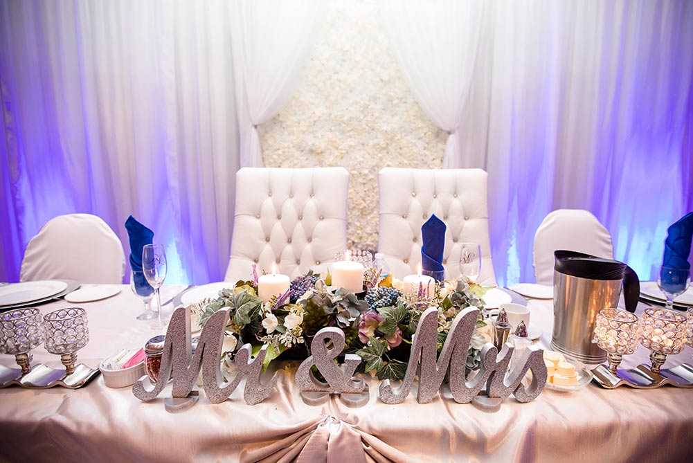 close up of blue, white and silver head table decor at wedding