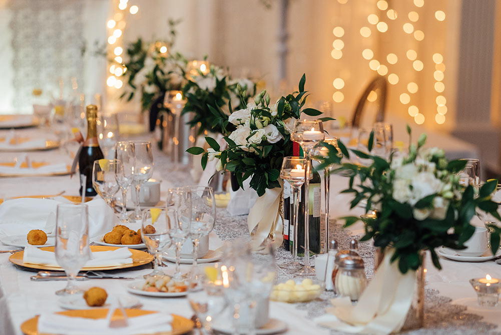 close up of table at wedding reception with gold charger plates and candles