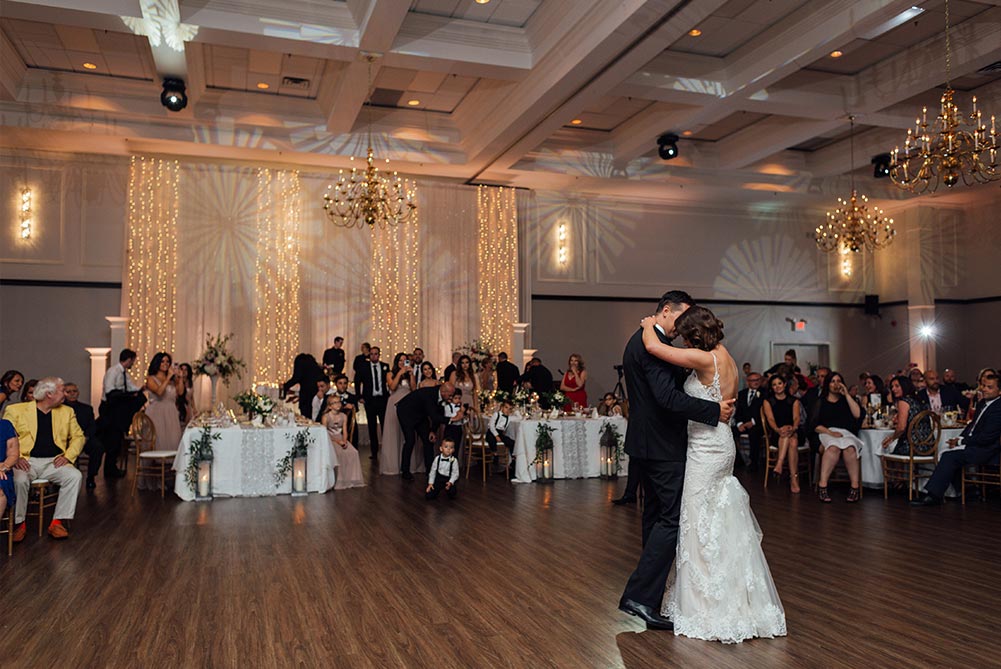 bride and groom having first dance in large ballroom