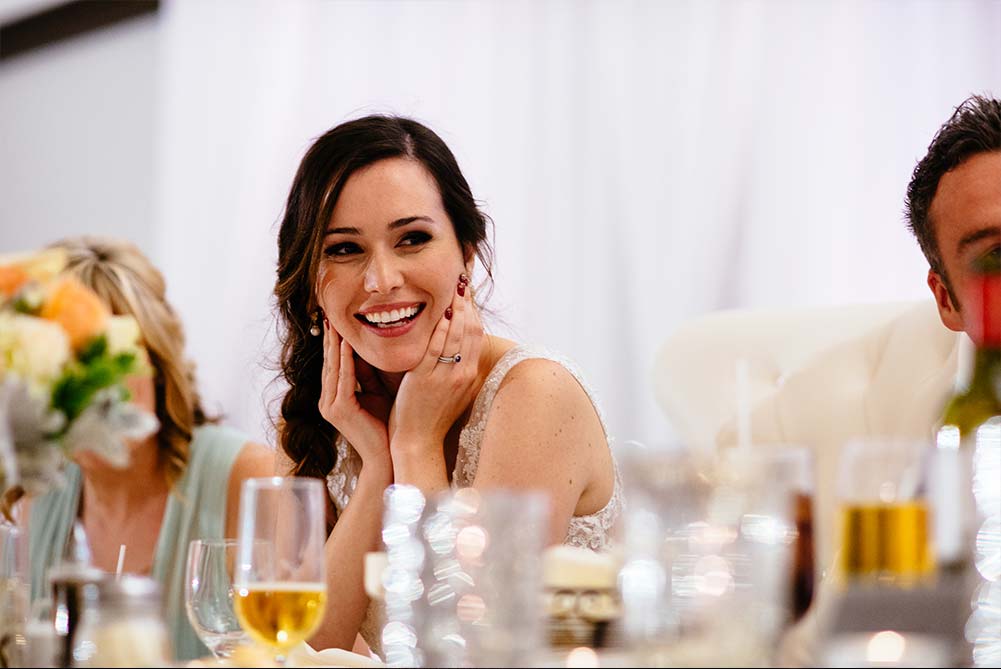 close up candid shot of bride laughing during wedding speeches