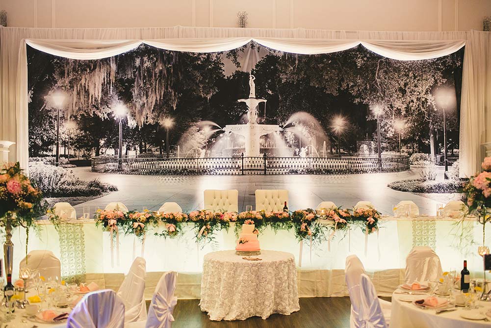 view of unique head table with photo backdrop showing black and white photo of chippewa square in Savannah Georgia