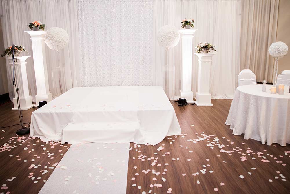 wedding ceremony set up with white stage and signing table