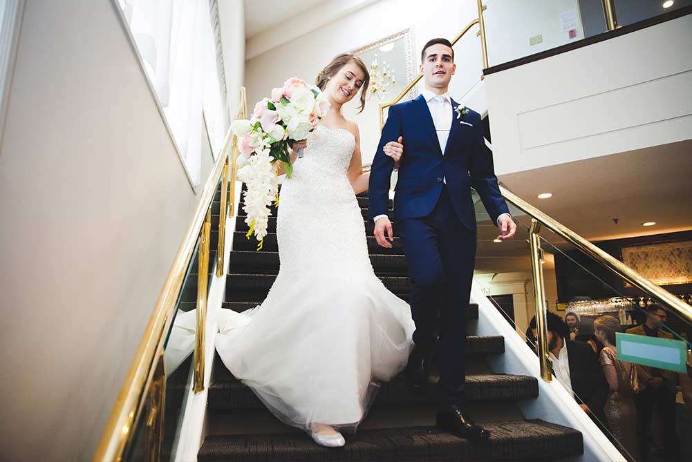 bride and groom descending stairs in Carmen's foyer