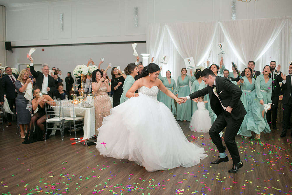 bride and groom dancing as guests throw confetti
