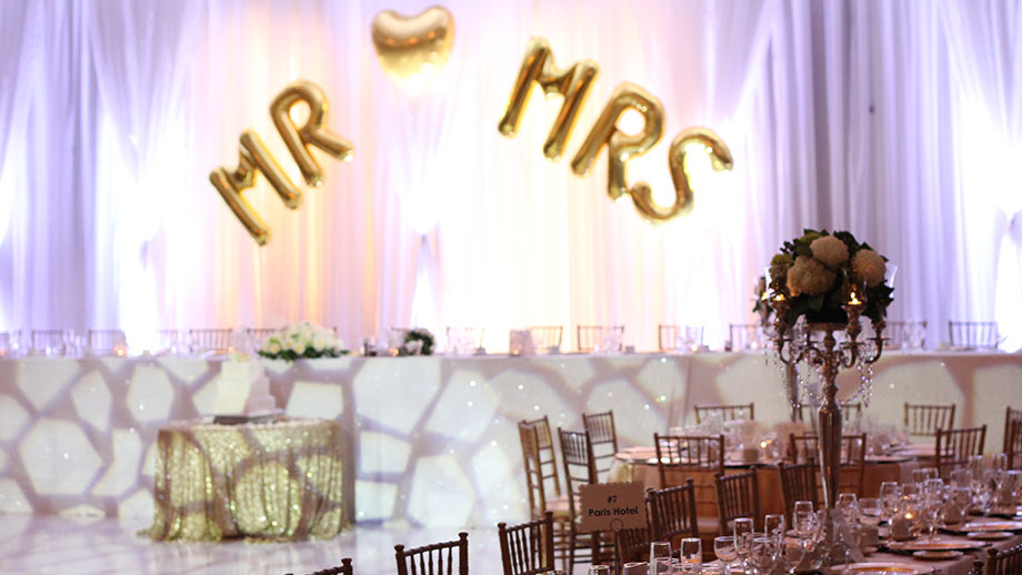 View of head table with inflatable gold letters spelling Mr & Mrs