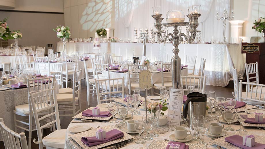 close up of wedding table setup showing silver charger plates, silver candelabra, and lilac napkins