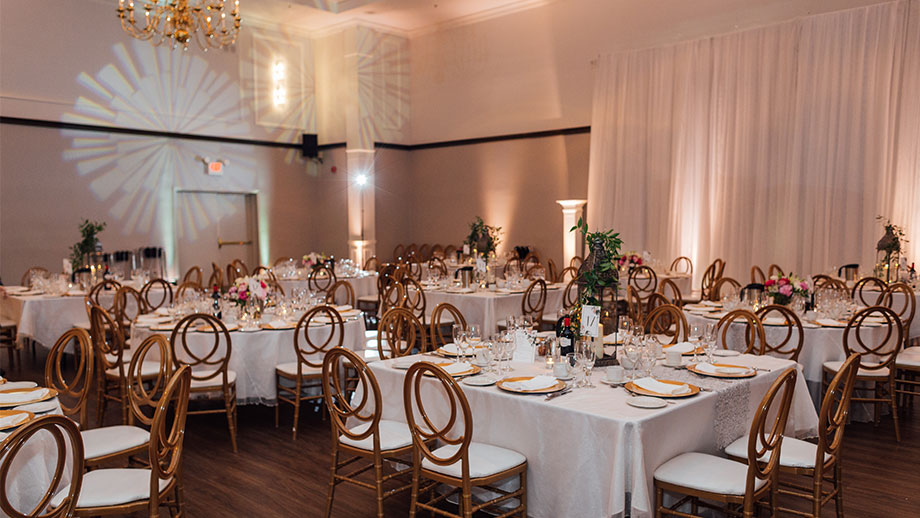 wedding reception with lantern centerpieces and gold charger plates