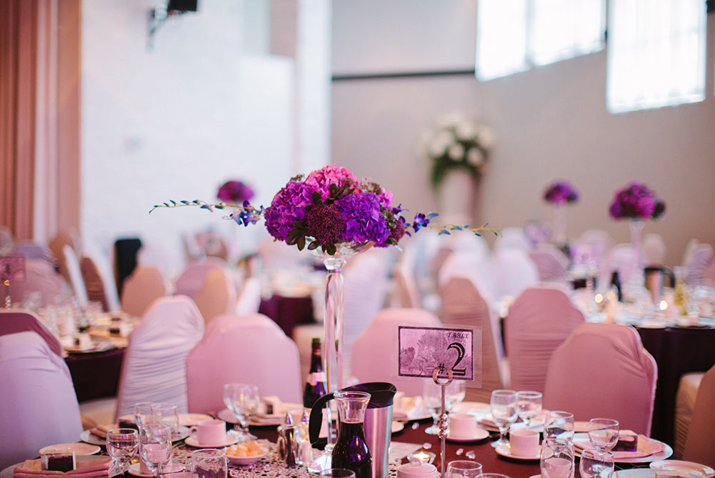 close up of wedding table decor showing purple hydrangeas and blue orchids