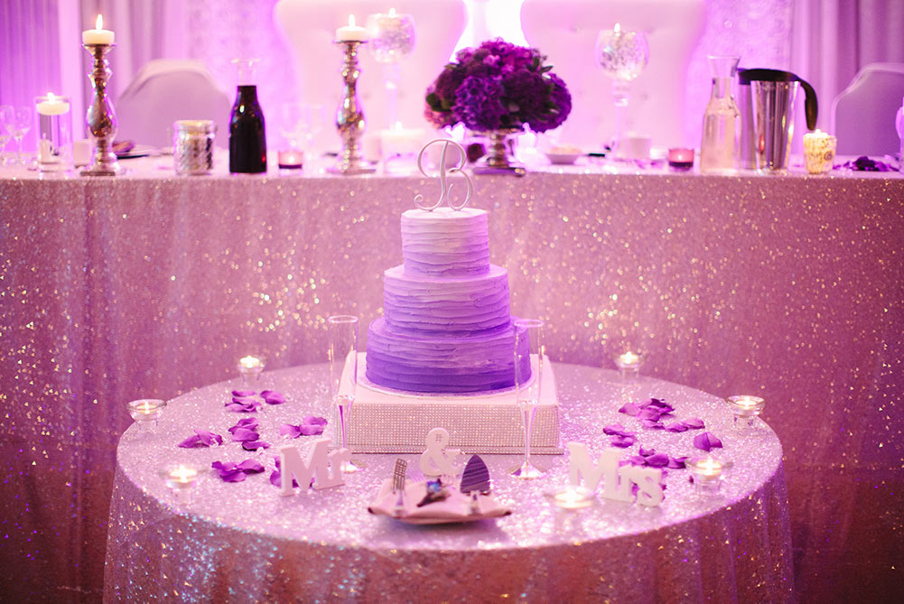 close up of cake table with sequin linens and purple ombre wedding cake